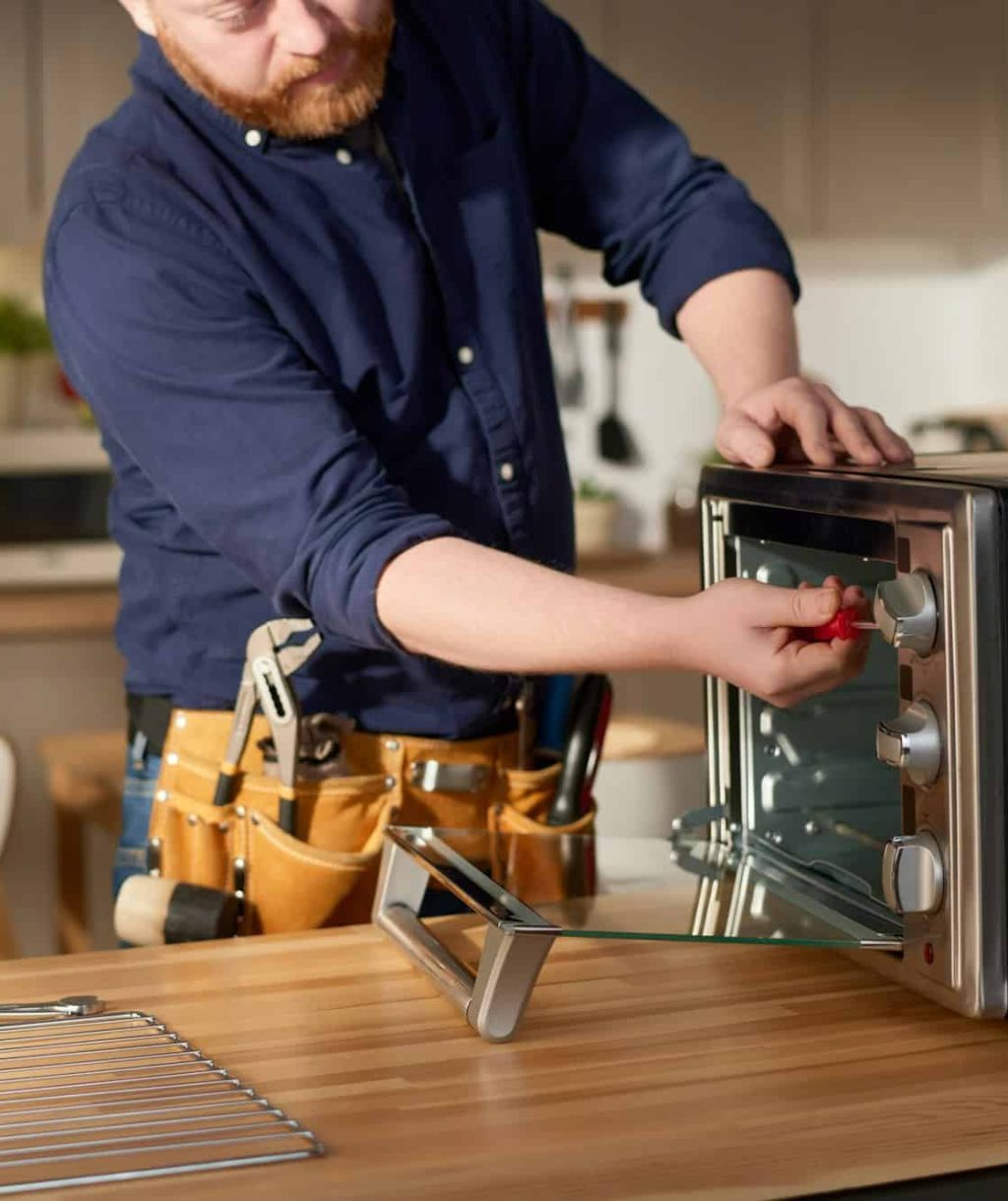 repairman-using-tools-to-fix-oven.jpg